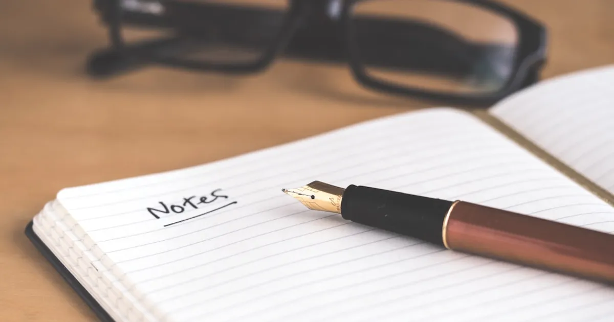 Diario de sueños abierto con una pluma sobre una mesa de noche